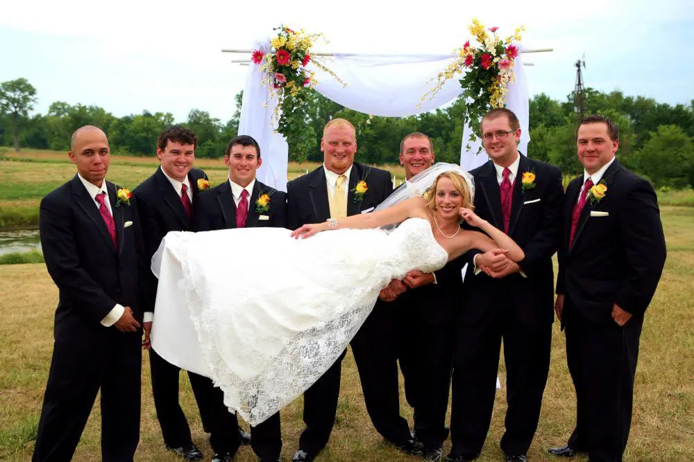 A bride and groom posing with their wedding party.